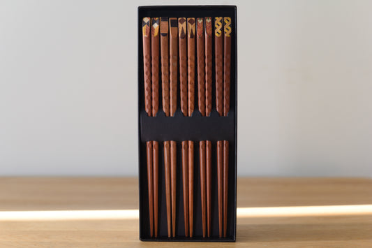 Fünf Paar Essstäbchen aus Holz mit gemusterten Griffenden in schwarzer Geschenkbox