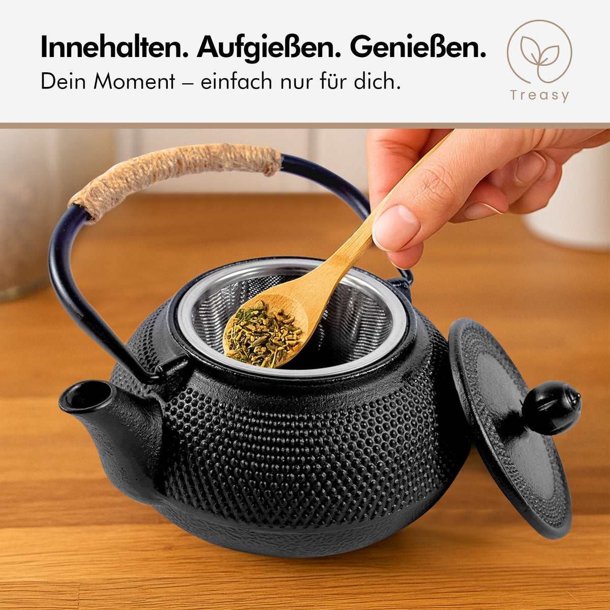 Loser Tee wird mit einem Holzlöffel in das Edelstahl-Sieb der Treasy Teekanne aus Gusseisen gefüllt